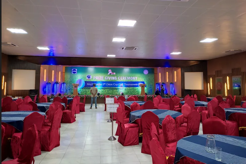 Banquet hall arranged with covered chairs and stage branding